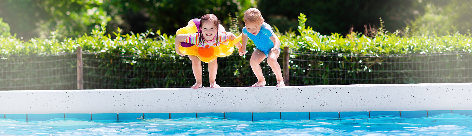 Zwei Kinder springen in einen Pool